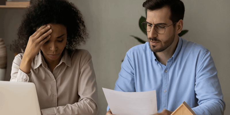 Landlord and Tenant Reviewing Rent Documents During Financial Hardship